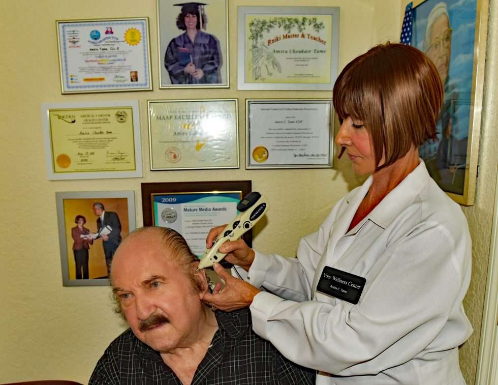 Amira using electro-pulse stimulation on a patient's ear